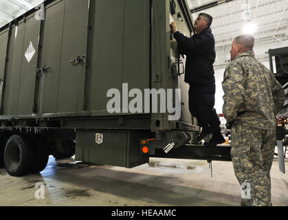 Coast guard Chief Warrant Officer 4 Bruce Jones, assigned to the Coast Guard Container Inspection Training Team, a native of Savannah, Ga., and Army Sgt. Dustin Price, assigned to the 4th Infantry Brigade Combat Team (Airborne), 25th Infantry Division, U.S. Army Alaska, a native of Concord, N.C., inspect the data plate for gross vehicle weight on a trailer before for transport to the port of Anchorage and follow on movement to the Joint Readiness Training Center at Fort Polk, La., on Joint Base Elmendorf-Richardson, Alaska, Feb. 24, 2014.  Justin Connaher Stock Photo