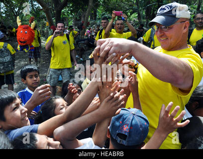 U.S. Army Col. John Sena, Soto Cano Air Base Army Support Activity Commander, hands out candy to Honduran children during the 52nd Joint Task Force-Bravo 'Chapel Hike' in Honduras, Feb. 8, 2014. More than 120 members of Joint Task Force-Bravo spent the day delivering more than 2,400 pounds of food and medical supplies to families in need in the mountain village of La Laguna, Honduras. To deliver the supplies, Task Force members carried the items on a more than seven-mile round trip hike, with an elevation gain of 1,700 feet. All of the food and supplies were purchased with funds donated by Tas Stock Photo