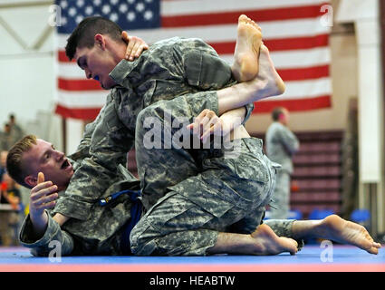 Spc. Joshua Sager, bottom, Headquarters and Headquarters Company, 3rd Battalion (Airborne), 509th Infantry Regiment, 4th Infantry Brigade Combat Team (Airborne), 25th Infantry Division, a native of Vernon, Texas, and Spc. Zakkary Cook, Headquarters and Headquarters Company 17th Combat Sustainment Support Battalion, a native of Virginia Beach, Va., both assigned to U.S. Army Alaska, compete in the first day of the 2015 USARAK Combatives Tournament at the Buckner Physical Fitness Center on Joint Base Elmendorf-Richardson, Alaska, Thursday, June 4, 2015. Less-experienced fighters will compete in  Stock Photo