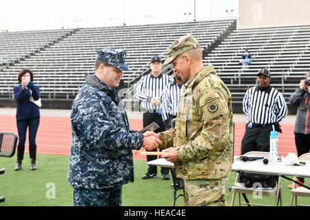 161118-N-EC099-003 TACOMA, Wash. (Nov. 18, 2016) Cmdr. Anthony Pecoraro, Naval Base Kitsap’s executive officer, and Joint Base Lewis-McChord Command Sgt. Maj. Michael Grinston, exchange plaques at the start of the 17th Annual Army/Navy Flag Football Game. The annual game has been a tradition since 2000 and it increases the morale and welfare of both Navy and Army personnel.  Petty Officer 3rd Class Charles D. Gaddis IV Stock Photo