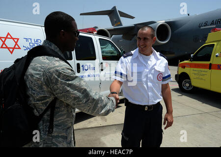 U.S. Air Force Capt. Jason Carter, medical readiness flight commander assigned to the 86th Medical Support Squadron at Ramstein Air Base, Germany, and Rockford, Ill., native, left, shakes the hand of Amit Michael, a Magen David Adom special medic, right, in front of a U.S. Air Force C-17 Globemaster aircraft and two Israeli ambulances after a simulated medical evacuation on the flightline of Ben Gurion Airport in Tel Aviv, Israel, May 20, 2014 as part of the Juniper Cobra 14 defense training exercise. JC14 is part of a long-standing agreement between U.S. European command and the Israeli Defen Stock Photo