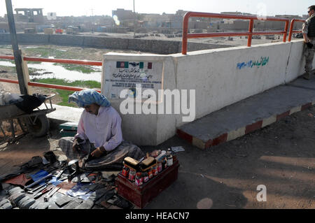 HERAT, Afghanistan-An Afghan local merchant sets up shop on the bank of the Karta Bridge in downtown Herat, Oct. 1, 2008.  The bridge was constructed by the International Security Assistance Force (ISAF) Italian Provincial Reconstruction Team-Herat in 2007.  The bridge took 6 months to complete and connects two major parts of the city.ISAF is assisting the Afghan government in extending and exercising its authority and influence across the country, creating the conditions for stabilization and reconstruction. (ISAF  U.S. Air Force TSgt Laura K. Smith)(released) Stock Photo