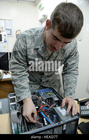 A client service technician repairs computers and manages IT support for personnel in Southwest Asia, assisting with over 2,200 tickets and up to 150 daily customer requests including account and telephone issues on April 3, 2015. Stock Photo