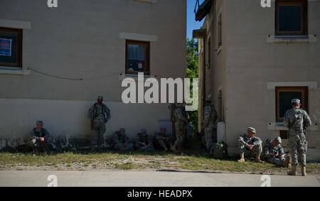 U.S. Army Soldiers from 1st Battalion, 118th Infantry Regiment, Joint Regional Detachment, North Carolina National Guard rest in between training lines during Kosovo Force Exercise (KFOR) 16, Joint Multinational Readiness Center, Hohenfels, Germany, Aug. 19, 2012. Three different training scenarios were preformed with media role players.  KFOR is a 15-day exercise used to prepare Soldiers to assume Multinational Battle Group-East and conduct peace support operations in parts of Nato's Kosovo Force.  Staff Sgt. Araceli Alarcon Stock Photo