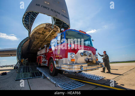 Loadmasters with the 439th Airlift Wing, Air Force Reserve Command, load a 1982 Mack 1250 GPM pumper fire truck onto a C-5B Galaxy at Joint Base McGuire-Dix-Lakehurst N.J., Aug. 12, 2016. Master Sgt. Jorge A. Narvaez, a traditional New Jersey Air National Guardsman with the 108th Security Forces Squadron, was instrumental in getting the truck donated to a group of volunteer firefighters in Managua, Nicaragua. The truck donation is done through the Denton Program, which allows U.S. citizens and organizations to use space available on military cargo aircraft to transport humanitarian goods to co Stock Photo