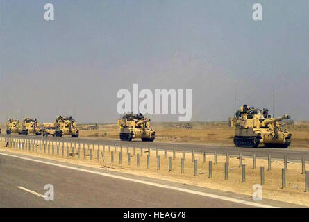 A convoy of US Army (USA) M109A6 155mm Paladin Self-propelled Howitzers travel along the highway on a march to the Euphrates River, in Iraq during Operation IRAQI FREEDOM. Stock Photo