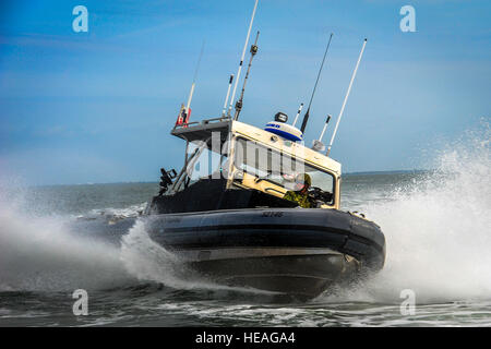 Members of the Port Security Unit 309 perform high-speed tactical boat maneuvers during a joint training exercise at MacDill Air Force Base, Fla., Feb. 26, 2015. The 309th worked with the 6th Security Forces Squadron marine patrol on various sustained force protection and port security tactics.  Senior Airman Ned T. Johnston Stock Photo