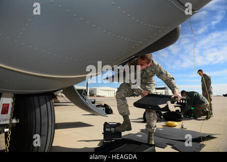 A maintainer from the 27th Special Operations Aircraft Maintenance Squadron installs armor in the wheel well of a factory-fresh MC-130J Commando II Dec. 18, 2014, at Cannon Air Force Base, N.M. Airmen fitted thousands of pounds of armor inside the gunship to ensure its protection downrange. (U.S. Air Force Photo/Airman 1st Class Shelby Kay-Fantozzi) Stock Photo