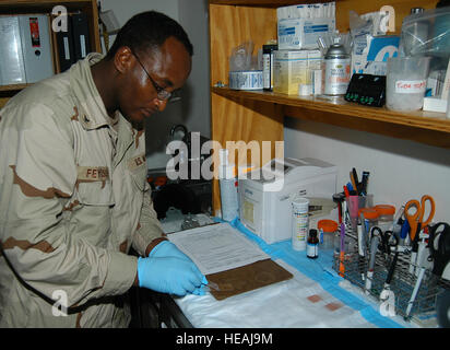 Navy Petty Officer 3rd Class Kinati T. Feyissa prepares a blood stain slide to be reviewed in the Seth Michaud Emergency Medical and Dental Facility at Camp Lemonier, Djibouti. The hospital corpsman is a Washington, D.C., resident who is part of a 35-man team providing medical services to service members supporting the Combined Joint Task Force-Horn of Africa mission to prevent conflict, promote regional stability, protect coalition interests and prevail against extremism. Feyissa is deployed from National Naval Medical Center in Bethesda, Md. Stock Photo