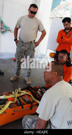 Staff Sgt. Froilan Constantino and Sgt. 1st Class Jason Kaaiakamanu of the Hawaii Army National Guards CERFP Search and Extraction team review patient packing procedures with members of the Philippine Military’s 7th ID search and rescue team, April 13, 2013, Subic Bay Philippines. Hawaii Army National Guard search and rescue experts are refreshing the skills of their Philippine counter-parts on the final day of a skill exchange before a two-day skill evaluation as a part of Balikatan. ( TSgt Andrew Jackson) Stock Photo