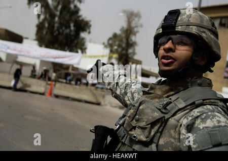 U.S. Army Multi-National Division - Baghdad Staff Sgt. Benjamin Concepcion a native of Waterbury, Conn., assigned the 3rd Squadron, 7th U.S. Cavalry Regiment, 3rd Infantry Division notifies his squad where they will be heading next during a dismounted patrol through the market place in the Adhamiyah District of Baghdad, Iraq, March 19, 2008. Tech. Sgt. Adrian Cadiz) Stock Photo