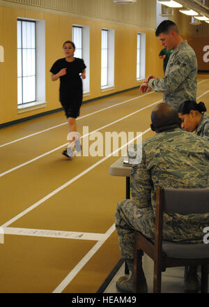 Airman 1st Class Cory Summers times CAP Cadet Airman 1st Class Lauren Daniel during her 1-mile run on the indoor track at the Fitness Center March 26. Airman Cortney Hansen) Stock Photo