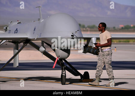 A dedicated crew chief prepares an MQ-1B remotely piloted aircraft for a training mission, May 13, 2013. The MQ-1B Predator is an armed, multi-mission, medium-altitude, long-endurance remotely piloted aircraft that is employed primarily as an intelligence-collection asset and secondarily for munitions capability to support ground troops and base defense.  432nd Wing/432nd Air Expeditionary Wing Stock Photo