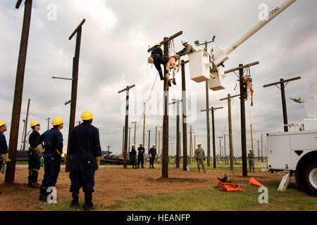 Navy Petty Officer 2nd Class Joshua Guerreiro, Navy Unique Block 7/CMCT instructor, 366th Training Squadron, was performing pole-top rescue procedures for the Navy Seabee Construction Electrician 'A' school initial pole-climbing qualification July 15, 2014, at Sheppard Air Force Base, Texas. The pole-top rescue climbing qualification simulates a climber who has been injured and the students need to provide assistance in retrieving them from the top of the pole.  Danny Webb/ Released) Stock Photo