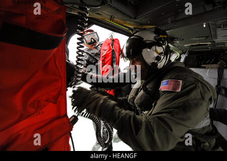 U.S. Navy Petty Officer 1st Class Charles Benjamin (right), Helicopter Squadron 10, hoists a Search and Rescue swimmer at Naval Air Station North Island, March 15, 2012. The Helicopter Squadron 10 crewmen preform their first training Search and Rescue open water helicopter jump before going on to the fleet.  Tech. Sgt. Chris Hibben Stock Photo