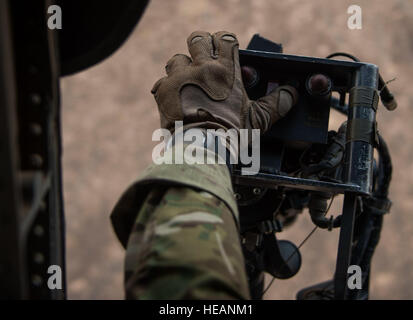 An aerial gunner with the 303rd Expeditionary Rescue Squadron arms his weapon flying in a UH-60 while conducting live fire weapons training working with Joint Tactical Air Controllers from Detachment 1, 82nd Expeditionary Rescue Squadron at the Arta range, Djibouti, June 22, 2015. The 303rd ERQS conducts training events working with enabling units to maintain proficiency while deployed in support of humanitarian aid and contingency operations in the Combined Joint Task Force Horn of Africa area of responsibility. ( Staff Sgt. Gregory Brook Stock Photo