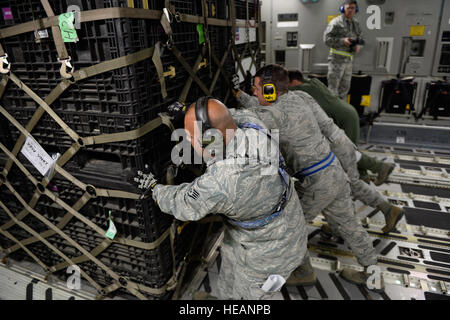 U.S. Air Force personnel load relief supplies for victims of the Nepal earthquake into a USAF C-17 Globemaster III from Joint Base Charleston, S.C., at March Air Force Base, Calif., April 26, 2015. The U.S. Agency of International Development relief cargo included eight pallets, 59 Los Angeles County Fire Department personnel and five search and rescue dogs. Stock Photo