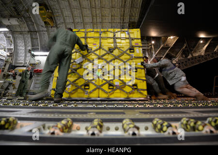 U.S. Air Force personnel load relief supplies for victims of the Nepal earthquake into a USAF C-17 Globemaster III from Joint Base Charleston, S.C., at March Air Force Base, Calif., April 26, 2015. The U.S. Agency of International Development relief cargo included eight pallets, 59 Los Angeles County Fire Department personnel and five search and rescue dogs. Stock Photo