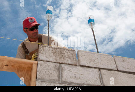 U.S. Air Force Master Sgt. Nicholas Alessi, New Horizons engineer 820th REDHORSE Squadron at Nellis Air Force Base, Nev., lays block at the Edward P. Yorke school construction site April 9, 2014, in Belize City, Belize. The site is one of five sites throughout Belize receiving new facilities built by U.S. military and Belize Defence Force engineers. The construction is part of New Horizons Belize 2014, an exercise geared toward mutual training and cooperation amongst Belize Defence Force, Canadian military, U.S. Air Force, U.S. Army and U.S. Marine Corps members. The opening ceremonies for the Stock Photo