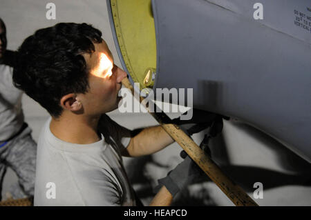 Staff Sgt. Ryan Letourneau, 379th Expeditionary Aircraft Maintenance Squadron, 340th Aircraft Maintenance Unit, adjusts a clamp after changing out the boom light on a KC-135 Stratotanker, October 27, 2008, at an undisclosed air base in Southwest Asia.  The KC-135 provides the core aerial refueling capability for the United States Air Force and also provides aerial refueling support to Navy, Marine Corps and allied nation aircraft operating in the Central Command area of responsibility.  Sergeant Letourneau is a native of Prosser, Wash., and is deployed from Fairchild Air Force Base, Wash., in  Stock Photo