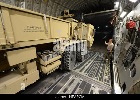 U.S. Air Force Senior Airman Nathaniel Hand, a cargo processor assigned to the 455th Expeditionary Aerial Port Squadron guides the driver of a Heavy Expanded Mobility Tactical Truck aboard a C-17 Globemaster III at Bagram Air Field, Afghanistan, June 21, 2014. The HEMTT is being redeployed back to the U.S. Hand is a native of Pueblo, Colo., and deployed from the 62nd Aerial Port Squadron, McChord Air Force Base, Wash.  Master Sgt. Cohen A. Young Stock Photo