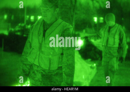 Staff Sgt. Robert Benton, of the 119th Maintenance Squadron, left, and Staff Sgt. Steven Kennedy, of the 219th Security Forces Squadron, shine flashlights on a sandbag flood levee as they monitor for possible problem areas of the flood protection barrier April 8, in residential backyards near 40th Ave. south in Fargo, N.D. The North Dakota National Guard members are monitoring the flood protection levees on 12-hour shifts, 24-hours a day until the flood waters recede. As of April 9, approximately 450 N.D. Air and Army Guardsman are on flood response for the 2011 flood fight. Stock Photo