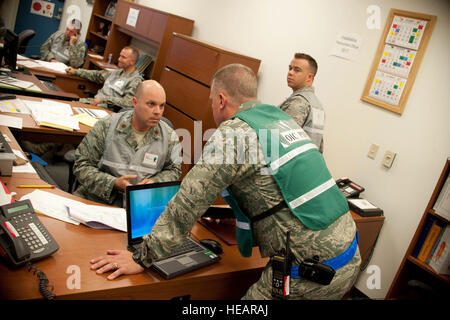 Maj. Joshua Clements, Installation Deployment officer, speaks with Lt. Col. Michael Knowles, Personnel Deployment Function officer in charge, in the Deployment Control Center during an Operational Readiness Inspection, Oct. 15, on Gowen Field, Boise, Idaho. Airmen from the 124th Fighter Wing are showcasing their ability to perform assigned tasks in a wartime, contingency or force sustainment operation. Inspection areas include initial response, employment, mission support and ability-to-survive and operate in a chemical environment. Stock Photo