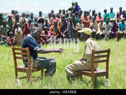 Ugandan animal and human health care workers perform a skit to educate villagers on sanitation and healthy living during a One Health mission in Kaabong district. One Health is a partnership of U.S. and foreign militaries, the African Field Epidemiology Network, and USAID, aiming to improve practices that prevent disease spread between animals and humans. The skits were part of a two-day village assessment for community education and health improvement. Stock Photo