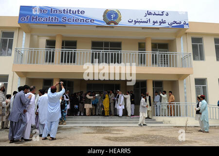 Attendees to the opening ceremony of the Kandahar Nursing and Midwifery Institute participate in the ribbon cutting May 9, 2012 in Kandahar, Afghanistan. The Kandahar Nursing and Midwifery will be able to train up to 800 students, both male and female, a year in nursing, midwifery, pharmacy, lab and dental services. Stock Photo