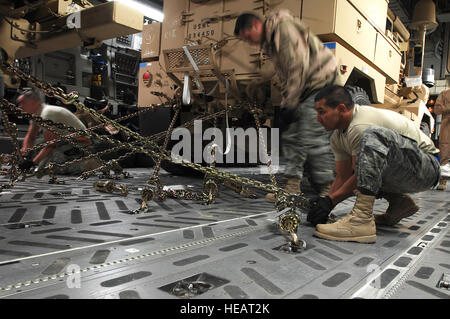 Airmen from 386th Expeditionary Logistics Readiness Squadron’s aerial port flight secure Mine Resistant Ambush Protected vehicles to the flooring of a Globemaster III cargo bay at an air base in the Persian Gulf region Feb. 8, 2008. The MRAP vehicles are a family of armored fighting vehicles designed to survive various types of improvised explosive device attacks and ambushes. These MRAP vehicles are being delivered to the Marine Corps regiments and battalions throughout the area of responsibility in support of Operations Enduring and Iraqi Freedom. Staff Sgt. Patrick Dixon) Stock Photo