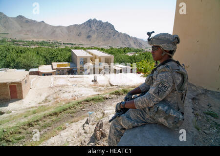 KAPISA PROVENCE, AFGHANISTAN -- U.S. Army Spc. David Duffy provides security overwatch during a meeting between members of USAID, U.S. Department of State, the sub-govener of Kohband and Provincial Reconstruction Team Kapisa in the village Shirinkel.  The meeting focused on a new USAID/Mercy Corps program to bring new jobs into the area to improve agriculture, sanitation and access to clean water.  Tech. Sgt. Joe Laws, USAF / Released) Stock Photo