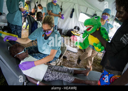 ARAWA, Autonomous Region of Bougainville, Papua New Guinea (July 1, 2015) Lt. Jenna Redgate (center left), dentist from San Diego, prepares to extract teeth from a patient during a community health engagement at the Arawa Medical Clinic as part of Pacific Partnership 2015. Medical personnel from the hospital ship USNS Mercy (T-AH 19) were at the clinic to provide residents with medical services and information to raise health awareness. Mercy is currently in Papua New Guinea for its second mission port of PP15. Pacific Partnership is in its 10th iteration and is the largest annual multilateral Stock Photo