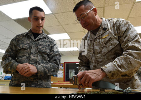 Airman 1st Class Dustin Lee, 3rd Operations Support Squadron aircrew flight equipment journeyman, explains the folding pattern of an F-22 Raptor parachute to Marine Corps Sgt. Maj. Anthony Spadaro, U.S. Pacific Command senior enlisted leader, at Joint Base Elmendorf-Richardson, Alaska, Oct. 21, 2016. Spadaro, a native of New Brunswick, New Jersey visited JBER for a three day immersion tour Oct. 19 to 21, 2016. Spadaro provides the PACOM commander with the enlisted perspective on theater security cooperation, encouraging peaceful development, responding to contingencies, and deterring aggressio Stock Photo