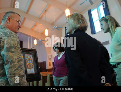 Lt. Col. Ken Harp, 97th Air Mobility Wing chaplain, shows Patty Solo, wife of 19th Air Force Commander Maj. Gen. Mark Solo, Maggie Elder, wife of the 97th AMW vice commander,  and Leah Thomas, wife of 97th Air Mobility Wing commander, the designs for the stained glass windows that are soon to be displayed in the base chapel Dec. 2. Solo toured base agencies supporting airmen and their families, such as housing, the Child Development Center, the Youth Center and the Wings of Freedom Park. Stock Photo