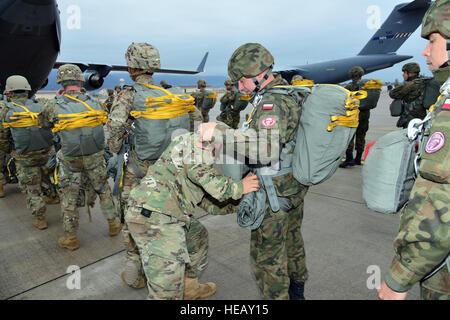 U.S. Army 1st Lt. David Blum, left, a jumpmaster assigned to the 54th Engineer Battalion, 173rd Airborne Brigade, conducts jumpmaster personnel inspection of Polish’s Army equipment, a paratrooper assigned to 6th Airborne Brigade, before an airborne operation at Aviano Air Base, Italy Oct. 19, 2016, as a part of Peacemaster Unity training. Peacemaster Unity is Joint multinational readiness exercise including participation from seven nations conducting missions across three countries, delivering over 2000 troops and 20 heavy drops. The 173rd Airborne Brigade is the U.S. Army Contingency Respons Stock Photo