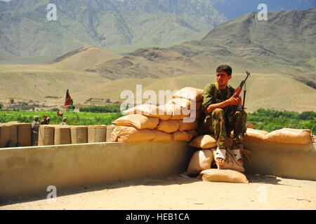 An Afghan National Army soldier soldiers provides security on the roof of an Afghanistan National Army compound in Parwa'i village in eastern Afghanistan's Nuristan province, Aug 26. The Nuristan PRT works closely with the Afghanistan National Army in order to achieve enhanced security, facilitate economic and infrastructure development and extend the reach of the Government of the Islamic Republic of Afghanistan.  U.S. Air Force Staff Sgt. Steven R. Doty) Stock Photo