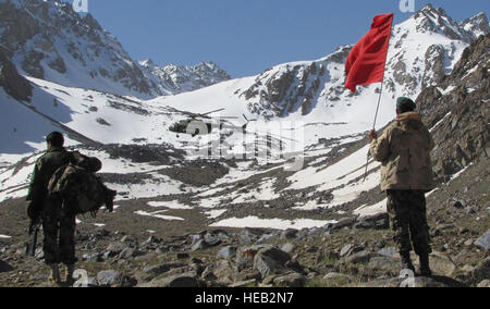 SALANG PASS, Afghanistan – Two Afghan National Army soldiers embark on their 1,000 foot journey up  a mountain  searching for human remains at the Pamir Airlines passenger crash site, while an Afghan National  Army Air Corps Mi-17 brings in more soldiers, May 21, 2010. The helicopters had to land at 12,000 feet while the remaining 1,000 feet was accomplished by soldiers on foot.  Tech. Sgt. Mike Tateishi/) Stock Photo