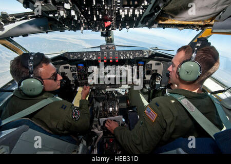 Capt. Taylor Ellington and 1st Lt. Matthew Street, both pilots assigned to the 92nd Air Refueling Wing, Fairchild Air Force Base, Wash., discuss notes while flying a Red Flag 15-3 training mission over the Nevada Test and Training Range, July 24, 2015. During Red Flag, KC-135s circle the skies refueling fighter aircraft to expand their training missions. Stock Photo