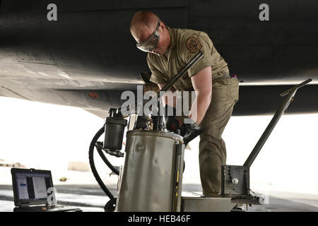 Airman 1st Class James Balcom, 37th Aircraft Maintenance Unit crew chief, fills the auxiliary power unit of a B1-B Lancer as part of his final inspections to ready the aircraft before an aircrew boards for a mission Sept. 22, 2015 at Al Udeid Air Base, Qatar. Balcom is deployed from Ellsworth Air Force Base, S.D. Staff Sgt. Alexandre Montes) Stock Photo