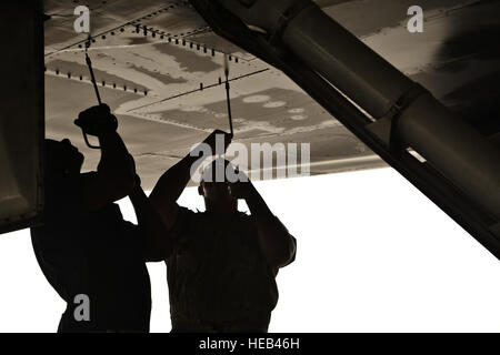 Tech. Sgt Nasir Ahmad and Airman 1st Class James Balcom, 37th Aircraft Maintenance Unit crew chiefs, remove a panel underneath a B1-B Lancer to check for leaks as part of a final pre-flight inspection Sept. 22, 2015 at Al Udeid Air Base, Qatar. Ahmad and Balcom are deployed from Ellsworth Air Force Base, S.D. Staff Sgt. Alexandre Montes) Stock Photo