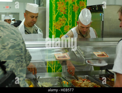 Chief Master Sgt. Jeffery Cui (left), 455th Air Expeditionary Wing command chief, and Brig. Gen. Steven Kwast (right), 455th Air Expeditionary Wing commander, serve Airmen food during a Thanksgiving day celebration, Nov. 26, 2009. The 455th AEW's leadership served meals on Thanksgiving as a way to boost the morale of the servicemen and women. Stock Photo