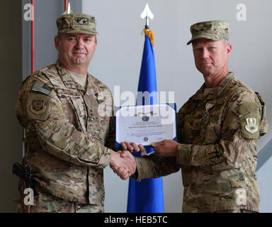 U.S. Air Force Maj. Gen. Scott West, 9th Air and Space Expeditionary Task Force-Afghanistan commander, poses for a photo with Brig. Gen. Mark Kelly, 455th Air Expeditionary Wing commander, after receiving an end of tour decoration July 1, 2015, at Bagram Air Field, Afghanistan. Kelly relinquished command to Brig. Gen. Dave Julazadeh.  Senior Airman Cierra Presentado Stock Photo