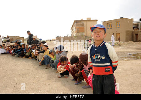 An Afghan child stops to pose for a picture while waiting to receive a stuffed animal during a recent Operation Care humanitarian mission at Bagram Airfield, Afghanistan. Operation Care is an all volunteer non-profit organization made up of service members and civilians, whose mission is to provide humanitarian assistance to  local civilians in remote areas of Afghanistan. Stock Photo