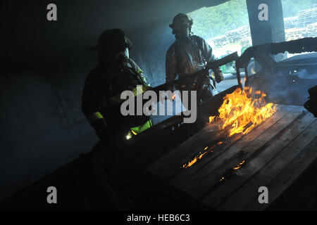 YAPHANK  NY –New York Air National Guard firefighters assigned to the 106th Rescue Wing, based at FS Gabreski Air National Guard Base in Westhampton Beach, NY,  deal with flaming debris during  training at the Suffolk County Fire  Academy here during their monthly drill  August 6th through the 8th, 2013. The firefighters reviewed basic skills in a realistic training environment under the eye of civilian firefighter trainers.  Senior Airman Christopher S Muncy 106th Rescue Wing / released) Stock Photo