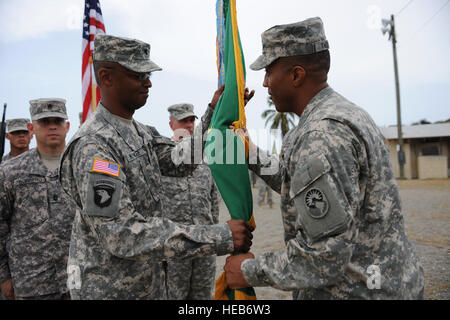 GUANTANAMO BAY, Cuba – Army Lt. Col. Christopher Wynder (left) receives the 525th Military Police Battalion colors from Army Col. Donnie Thomas, Joint Task Force Guantanamo’s Joint Detention Group commander, symbolizing Wynder’s appointment as 525th MP Battalion commander during a change of command ceremony, July 13, 2010. The 525th MP Battalion makes up a portion of the guard force at JTF Guantanamo. JTF Guantanamo provides safe, humane, legal and transparent care and custody of detainees, including those convicted by military commission and those ordered released by a court. The JTF conducts Stock Photo