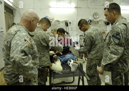 U.S. Army medics from the 6th Squadron, 9th Armored Reconnaissance Regiment, 3rd Brigade Combat Team, 1st Cavalry Division provide medical assistance to an Iraqi police officer with gun shot wounds to both legs at Forward Operating Base Normandy, Iraq on March 24.  Staff Sgt. Stacy L. Pearsall) Stock Photo
