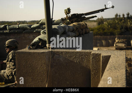 A U.S. Army soldier from Alpha Troop, 6th Squadron, 9th Armored Reconnaissance Regiment, 3rd Brigade Combat Team, 1st Cavalry Division sits near an Iraqi army machine gun on the roof of a building in Shakarat, Iraq on March 22.  Alpha Troop Soldiers conduct patrols and build an Army combat outpost in Shakarat.   Staff Sgt. Stacy L. Pearsall) Stock Photo