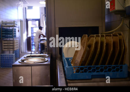 Newly washed dishes roll out of a dish washer at the Rheinland Inn dining facility Aug. 23, 2016, Ramstein Air Base, Germany. Airmen and civilian employees who work at the DFAC are required to keep the facility and its resources as clean as possible.  Airman 1st Class Joshua Magbanua) Stock Photo