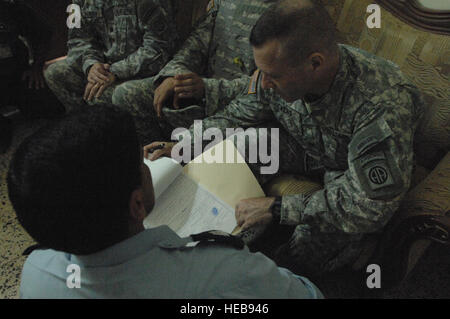 An Iraqi policeman shows Army Col. Bryan Owens, Commander of 3rd Brigade Combat Team, 82nd Airborne Division, all the paperwork they have on the suspected insurgents that they have captured in the city of Siniyah, Iraq, Aug. 18. Stock Photo