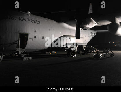 YOKOTA AIR BASE, Japan -- Crew chiefs from the 374th Aircraft Maintenance Squadron perform preventive maintenance on a C-130 Hercules here March 31, 2011. As part of Operation Tomodachi, the U.S. military has mobilized its humanitarian airlift capabilities to support emergency relief efforts throughout quake and tsunami affected regions of Japan that are. Yokota’s location and tactical airlift capability makes the base a key element of these efforts. Airman 1st Class Andrea Salazar) Stock Photo